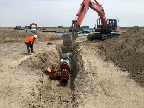 Employees conducting work inside a dug out ditch at the Hanford site