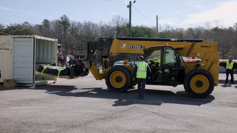 Employees using machinery to load a large shipment