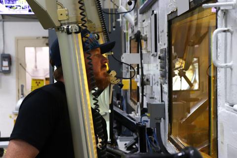 An employee operating a hot cell box