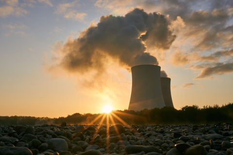 Sun rising behind nuclear power plant cooling towers