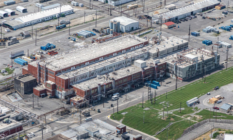 An aerial view of a large brick facility building at the Oak Ridge Site