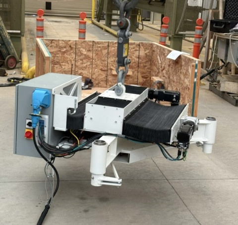 A white, black and grey piece of robotic machinery