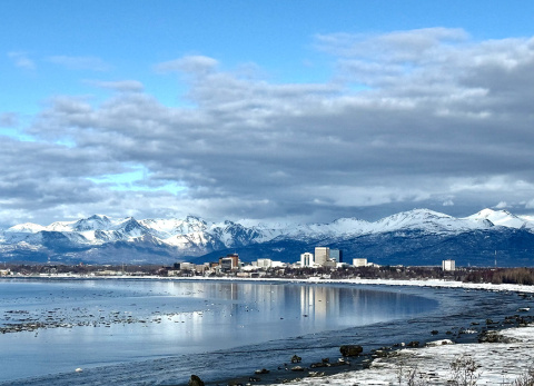 A bay with buildings and mountains in the distance.