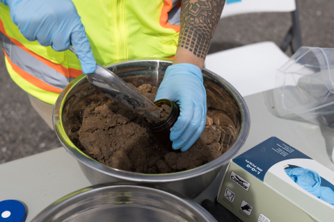 Up close of an employee scooping a soil sample 