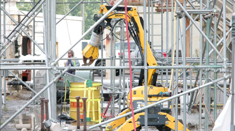 A large yellow robotic arm doing a mock-up demonstration at the Oak Ridge Site