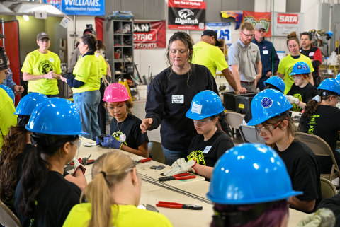 Young girls in blue hard hats take place in a STEM camp at the Hanford Sire