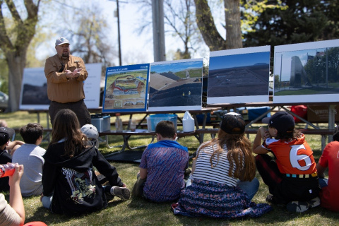 A man giving a presentation outside to children at a water festival