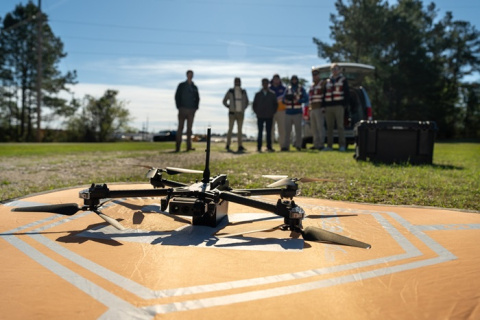 Drone on ground with workers looking on