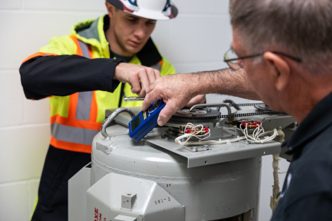 Two men take radiation readings on a dismantled cesium irradiator before removing it.
