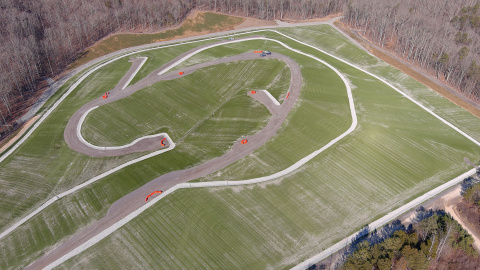 An aerial view of a large green cleared area with roads throughout it 