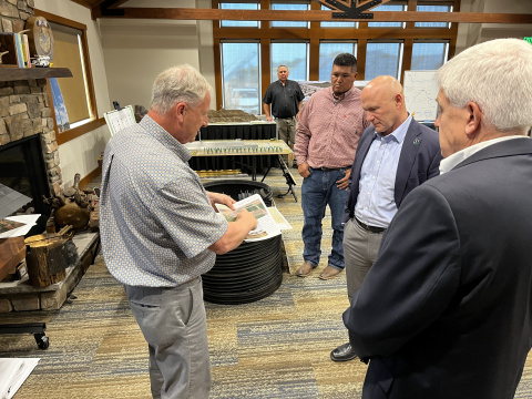 A photo of individuals standing around a room speaking with each other