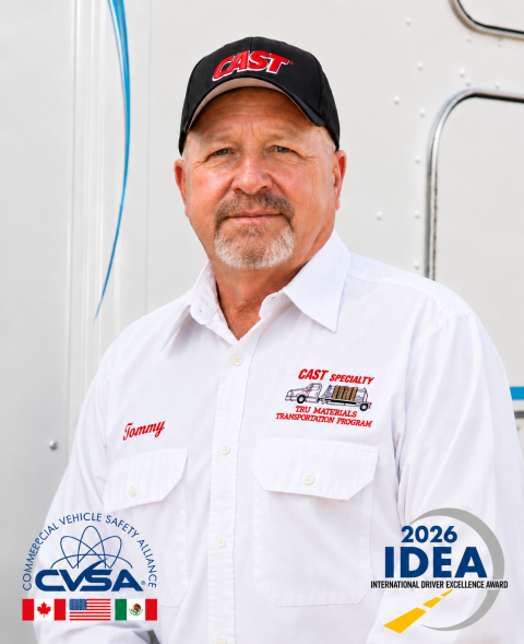 A professional headshot of a man in a white shirt and black hat