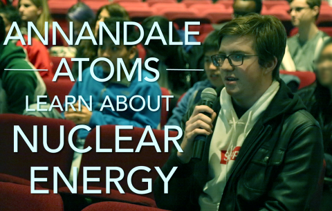 A student with a microphone asks a question during a visit from the Department of Energy.
