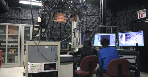 Two researchers look at a computer screen.