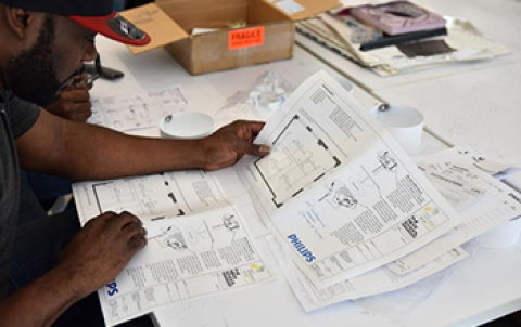 Photo of a man reading a specification sheet.