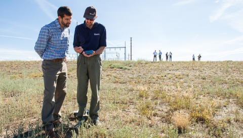 Photo of two people surveying a site for solar resource