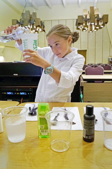 BERA camper and science fair participant Jenna Mehlinger, daughter of Janine Mehlinger in the Business Services Directorate, prepares her experiment for the fair.