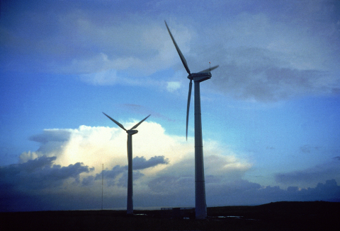 Two wind turbines in a field.