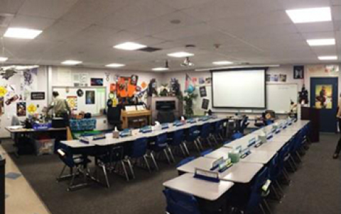 A photo of a classroom with desk and chair, and overhead lighting. 