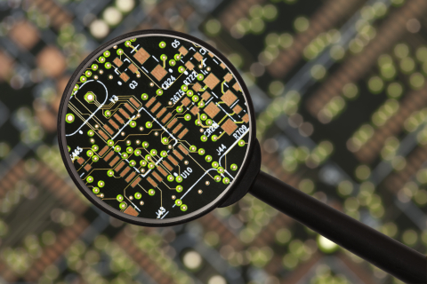 computer chip being examined with a magnifying glass