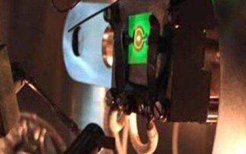 A green LED being electrically powered inside an ultra-high vacuum electron emission spectroscopy chamber.