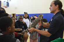 Sean Poppy, outreach coordinator for the University of Georgia’s Savannah River Ecology Laboratory outreach program, shows a juvenile alligator to students at Blakeney Elementary School in Waynesboro, Georgia.