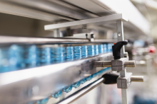 Translucent blue plastic containers lined up on a metal rail system.