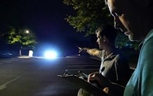 Two people outside at night in a parking lot.