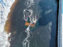 Aerial view of a device underwater in a river with snow covered banks