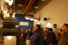 People standing in a hallway looking at a display of different kinds of lighting.