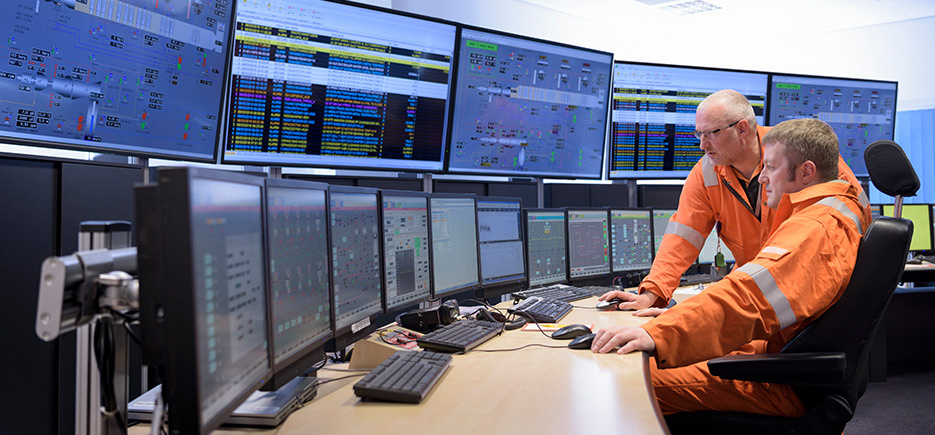 Two engineers at control monitors.
