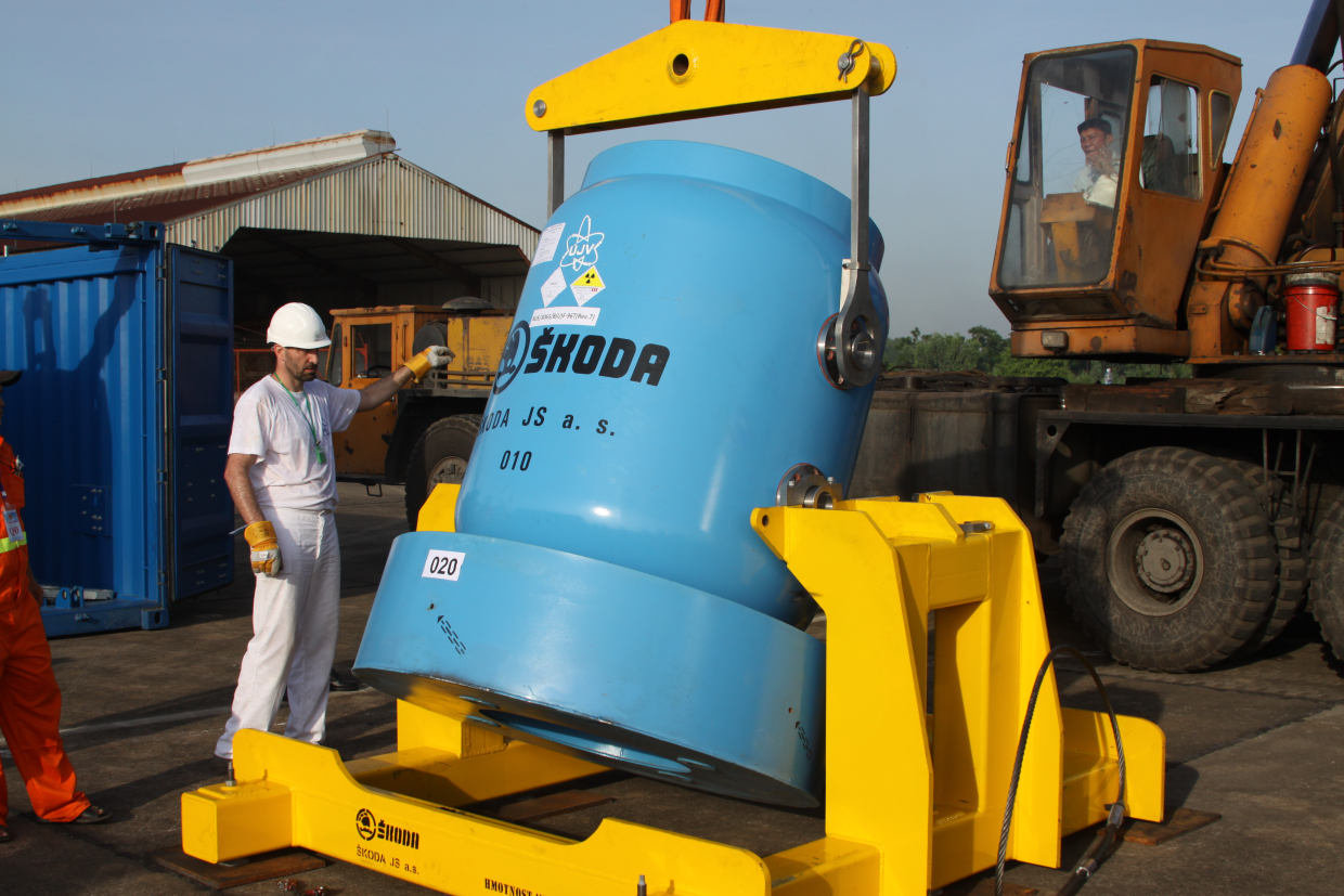 Large blue container and a technician in a white hard hat in Vietnam for an HEU removal