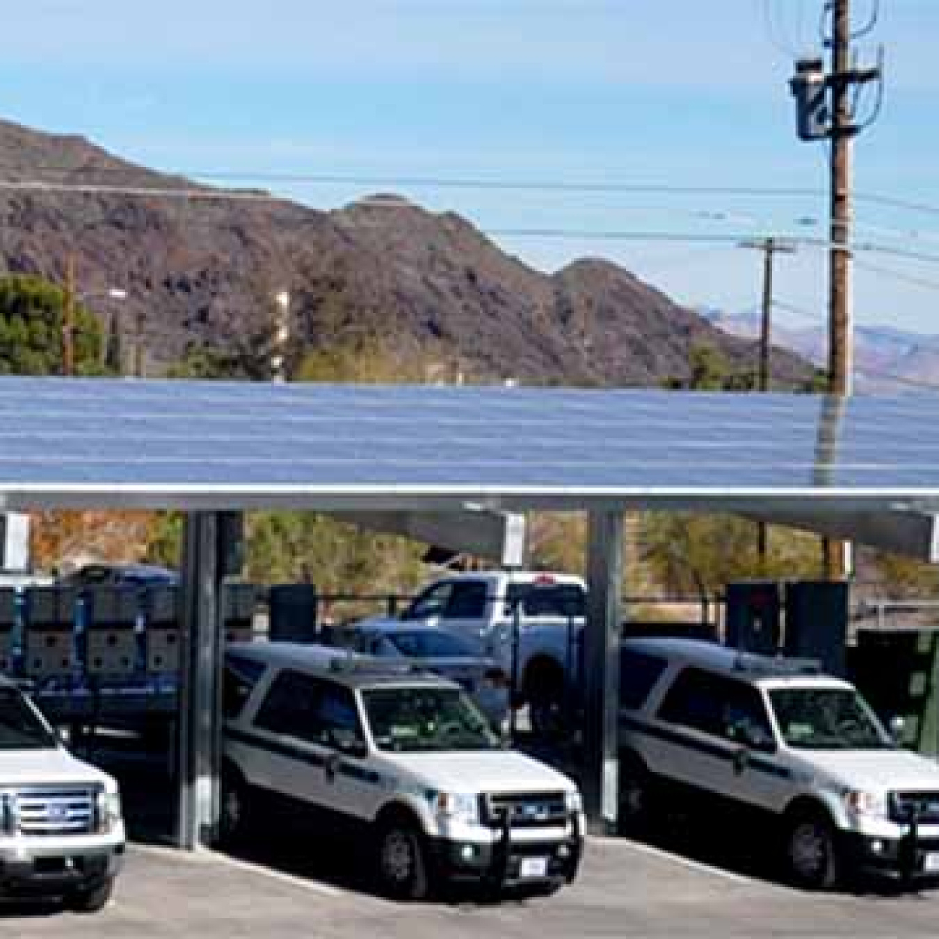 Cars parked under a roof of solar panels.