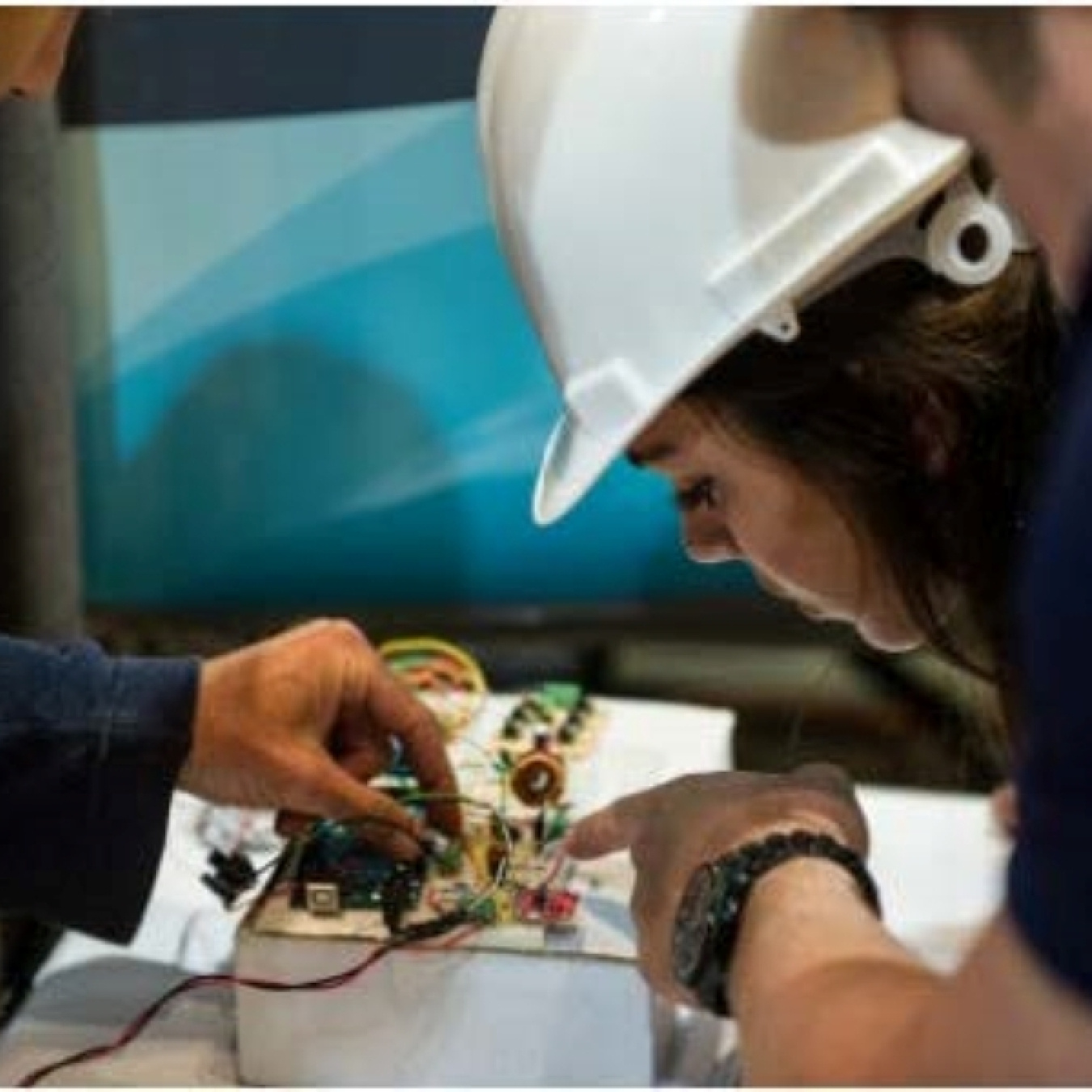 Students inspect wiring and electrical components on the small wind turbine they designed and built for the DOE Collegiate Wind Competition.