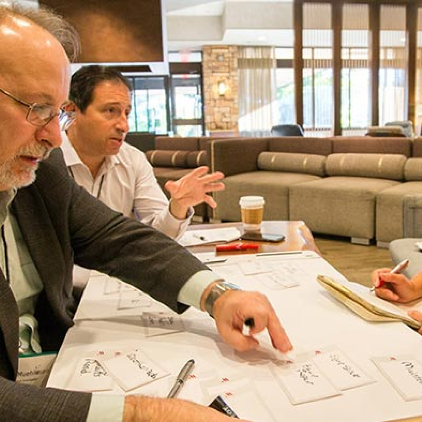 Image of three people, two males and a female, working together at a table.