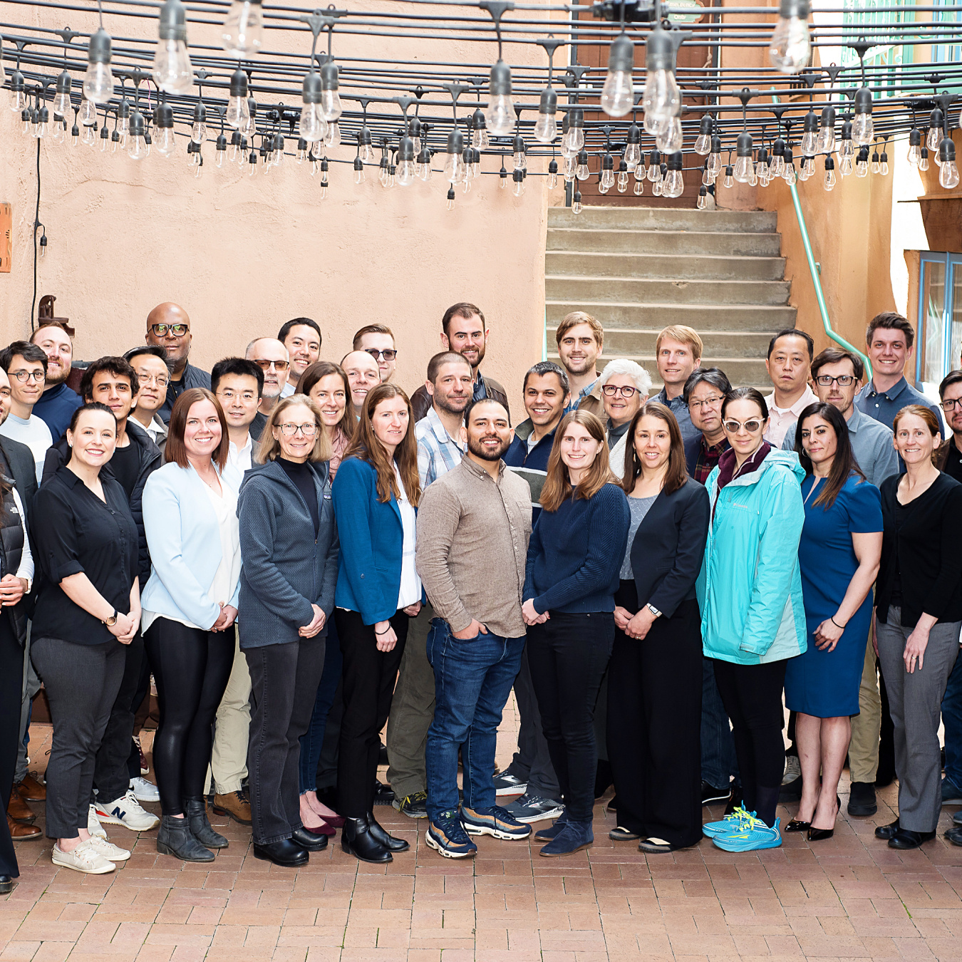 A group of 40 people pose for a photo in an outdoor patio.