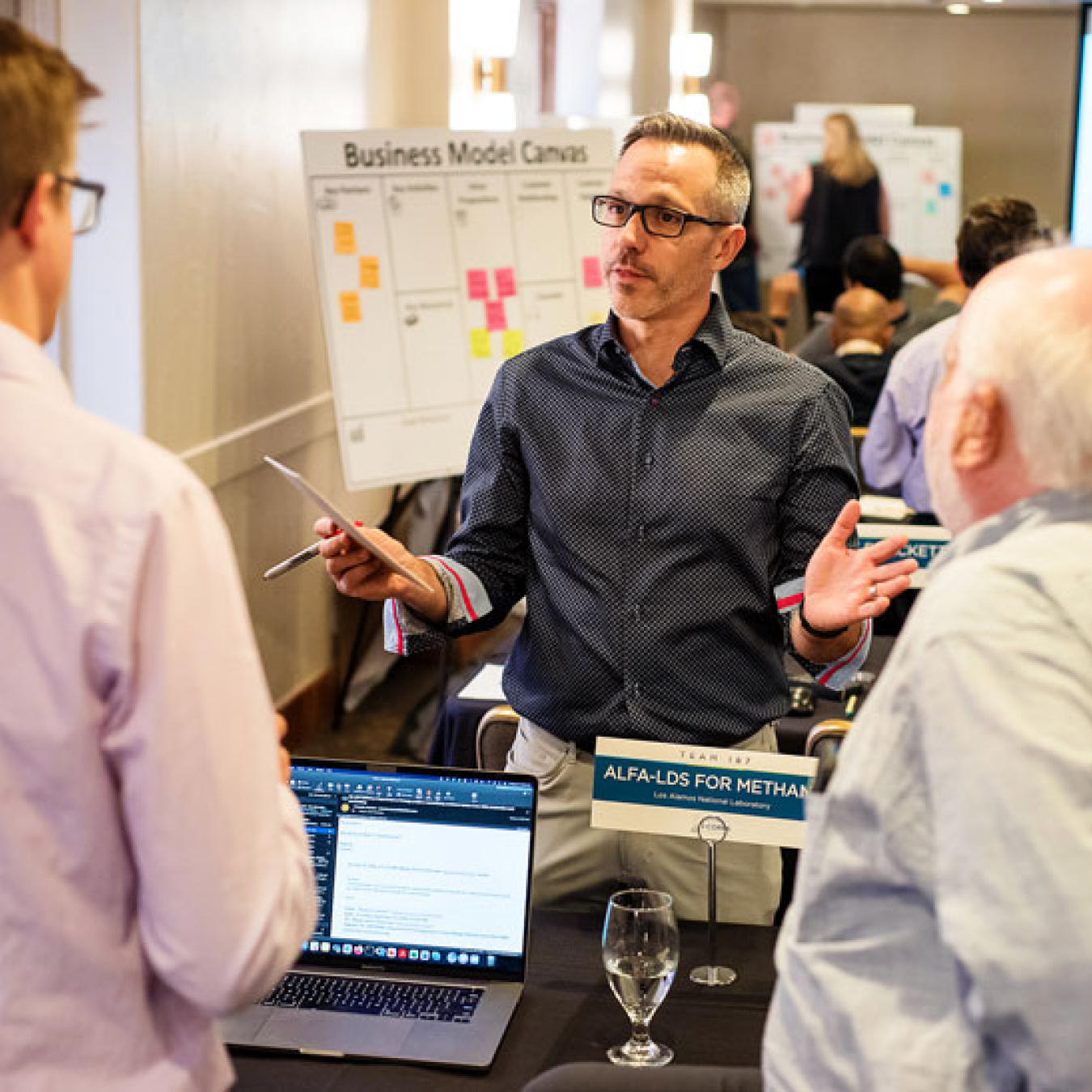 A trio of people talk candidly in a meeting room.