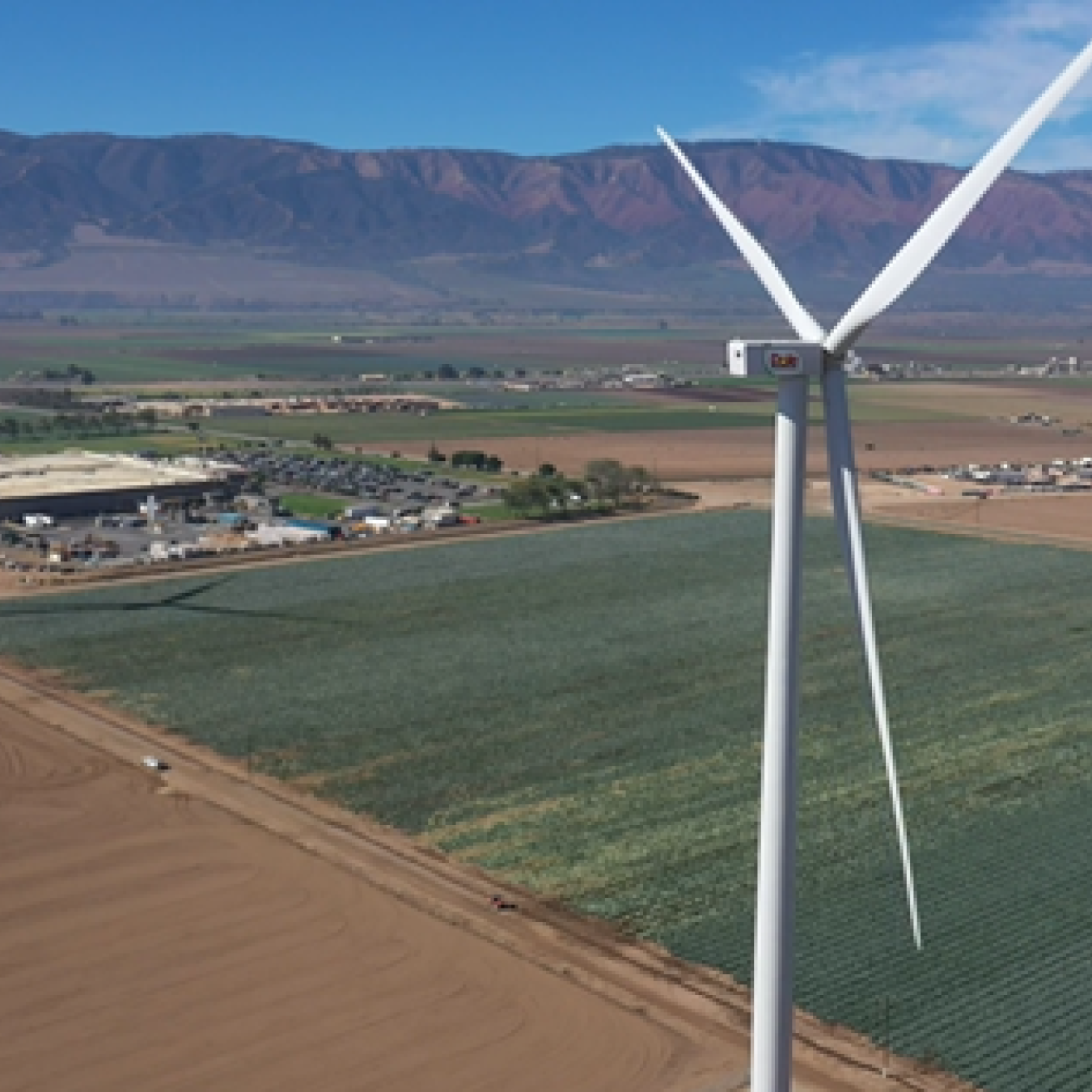 Two wind turbines in a large, open field.