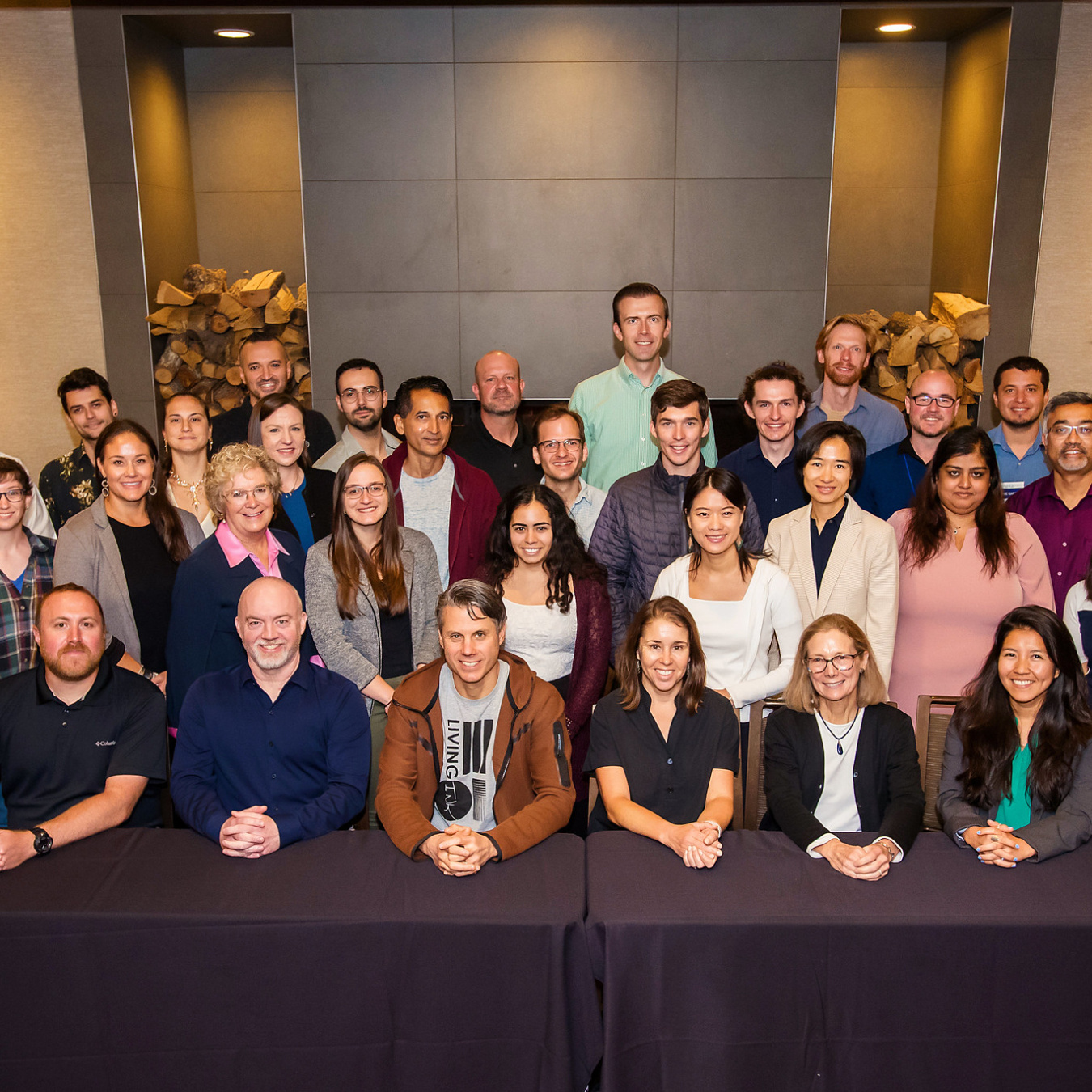 A group of 34 people pose and smile for the camera.