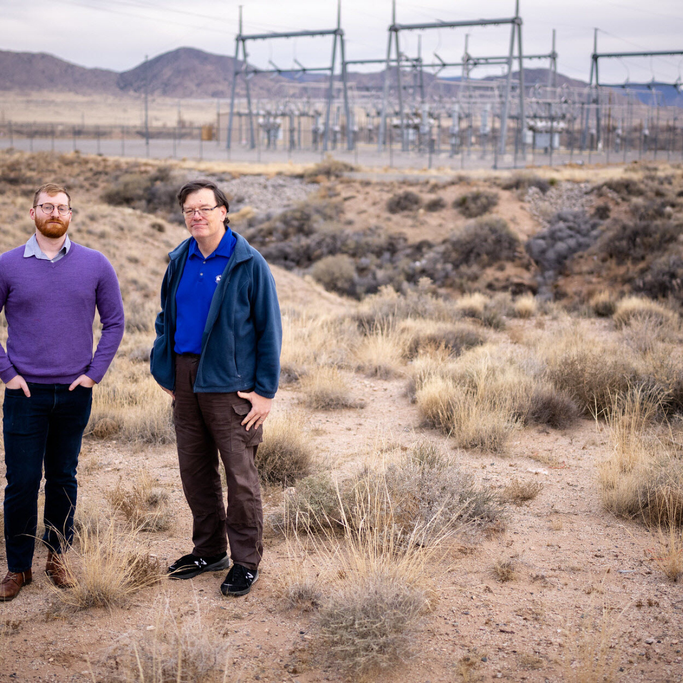 two men standing in desert field