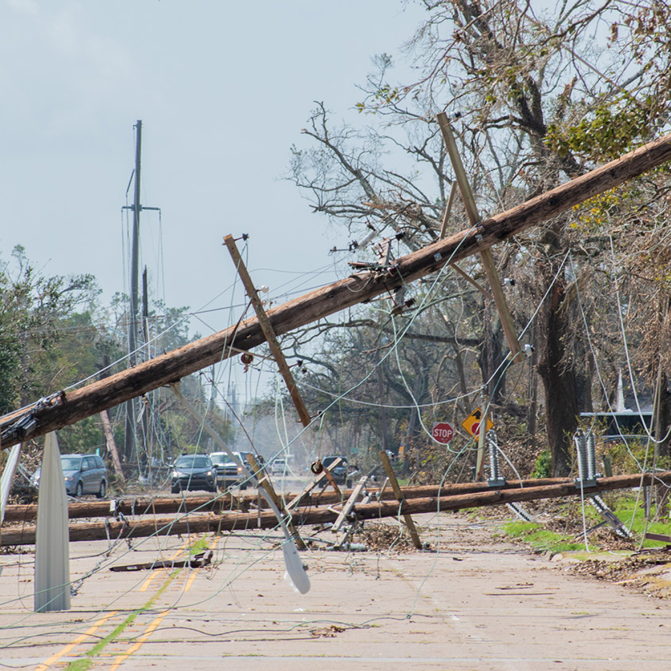 Power lines and poles lying over a street after a storm.