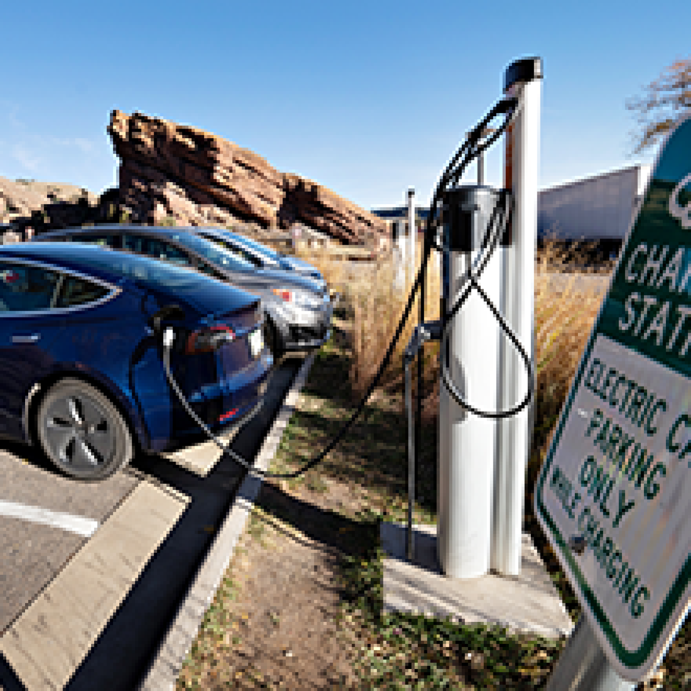 Electric vehicle parked and charging at a charging station in the Red Rocks Park in Colorado.
