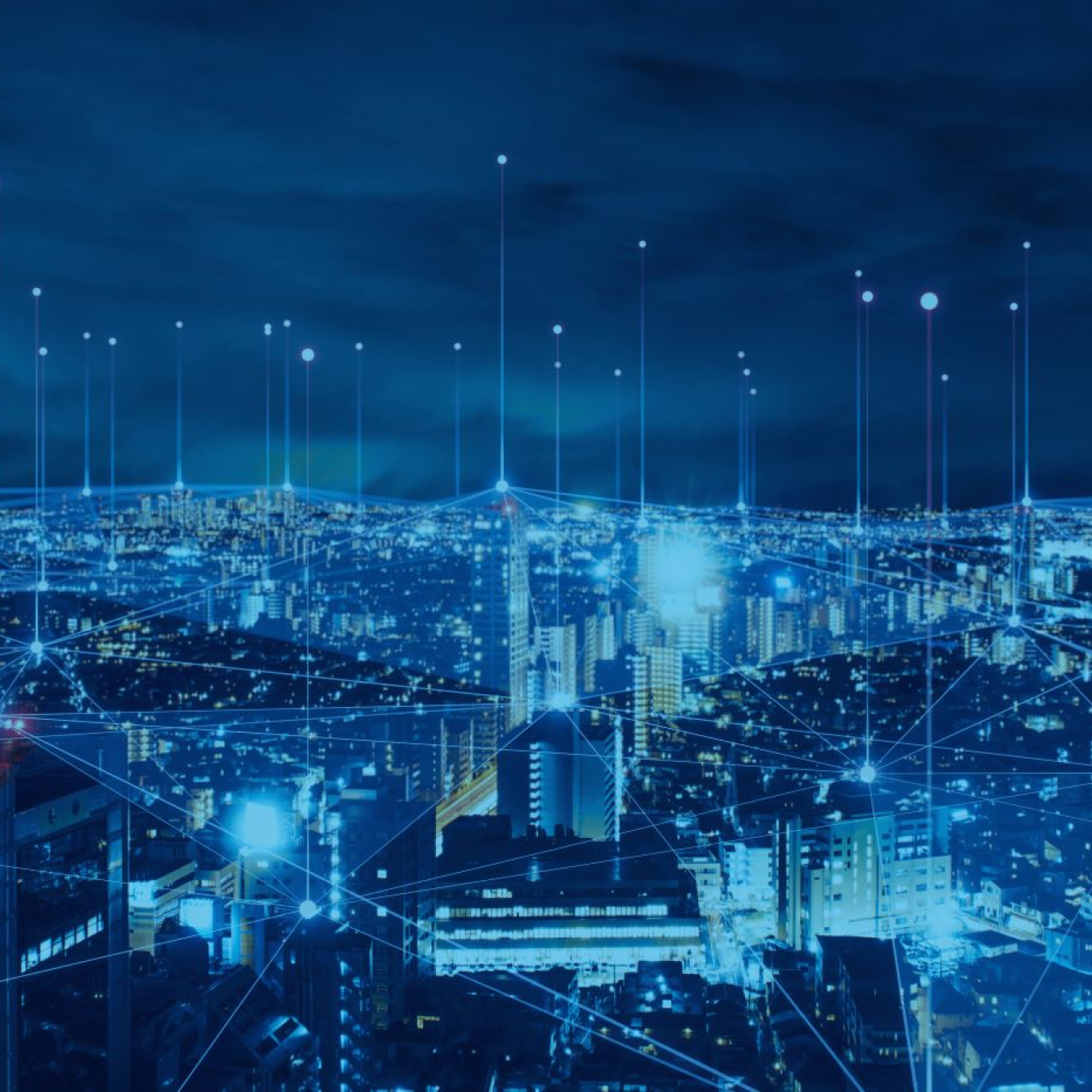 An image of an electrical grid overlaid against a cityscape at night.
