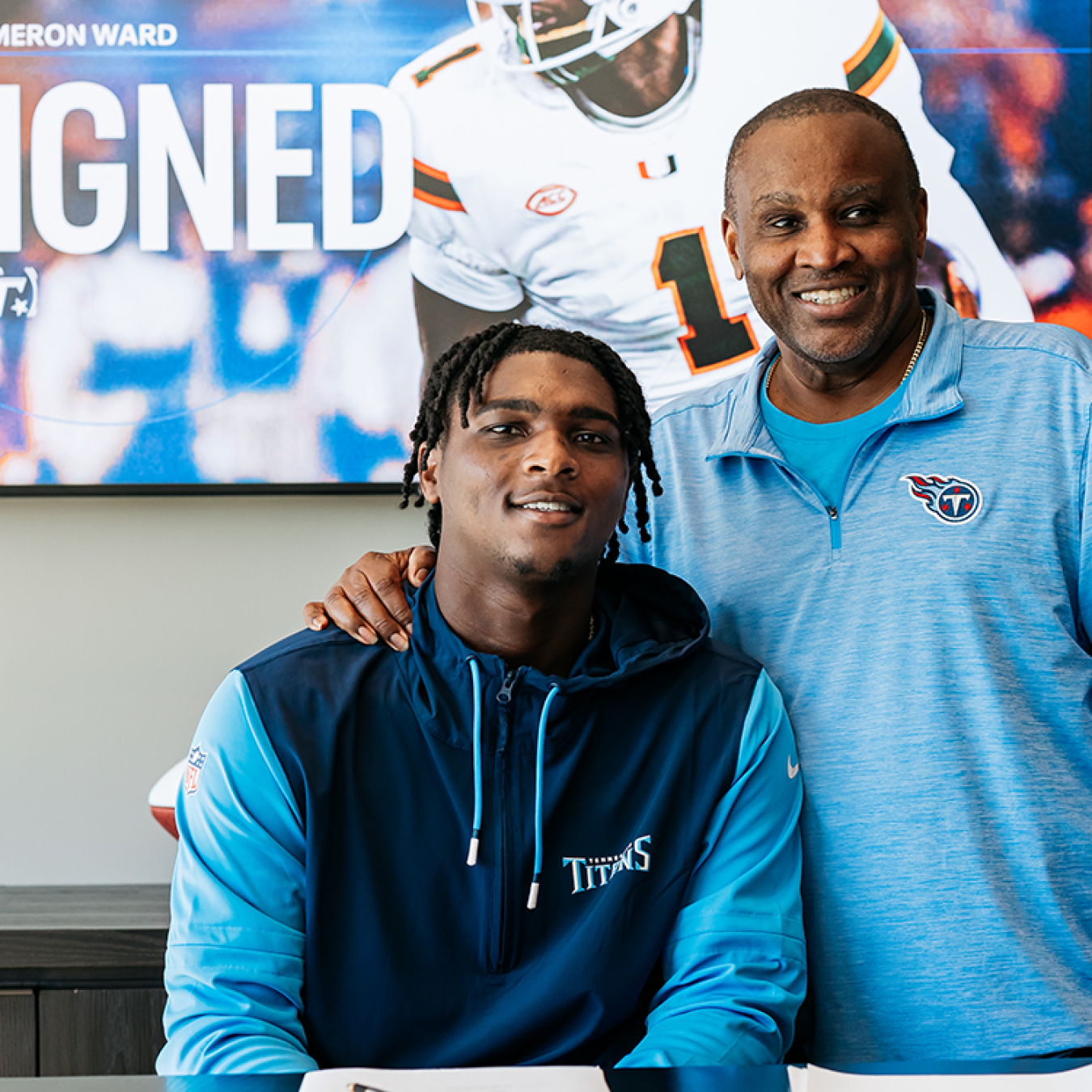 Cam Ward signing for the Tennessee Titans alongside his father, Calvin.
