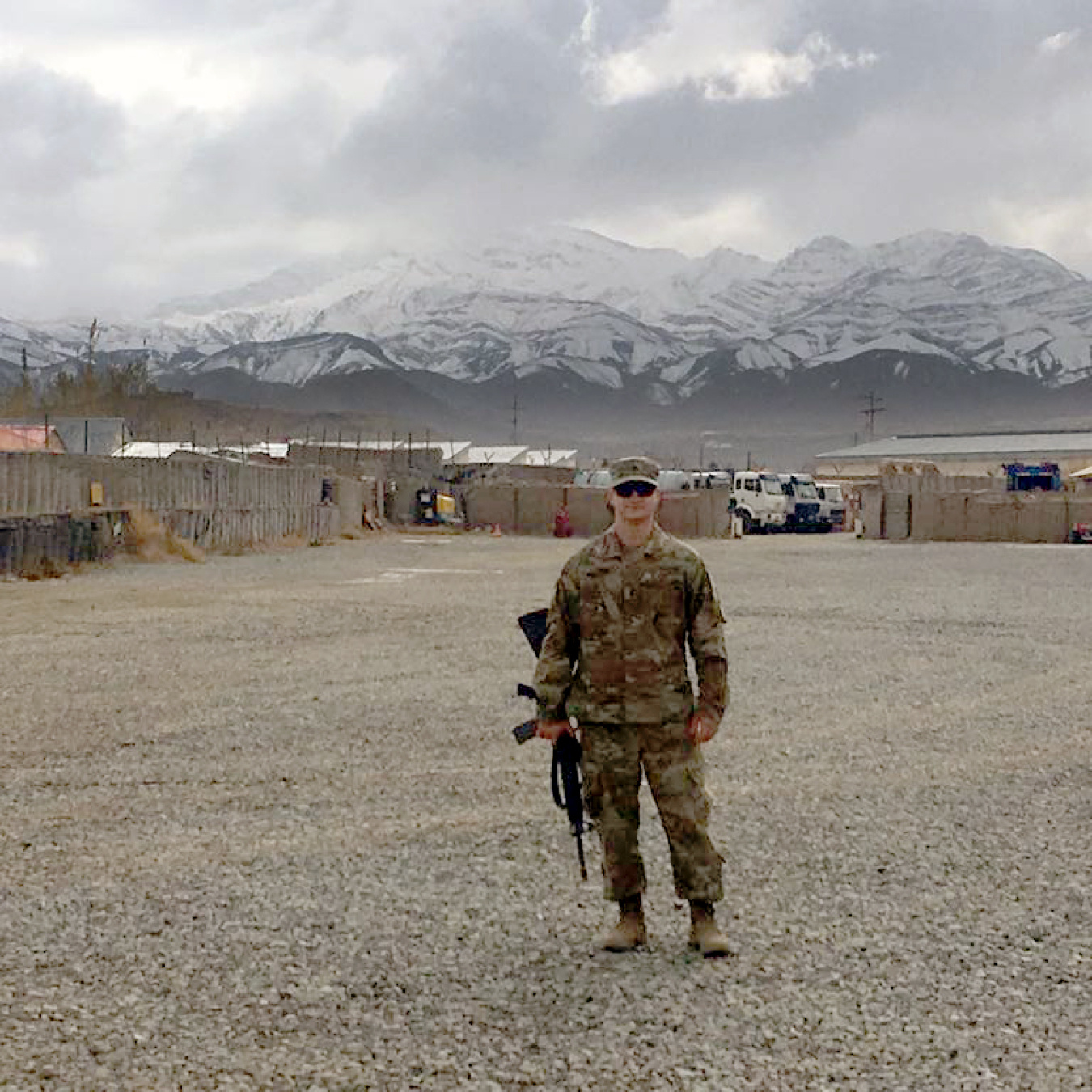 A man in a Military uniform posing for a picture outside