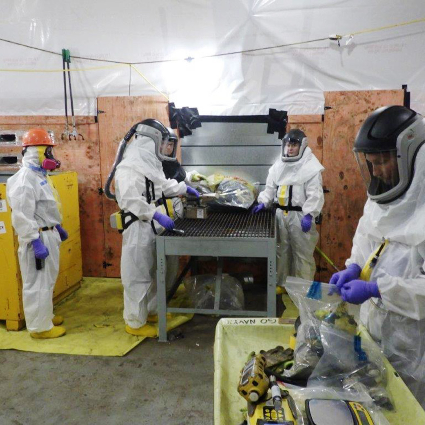 Sanitation workers in white safety gear working