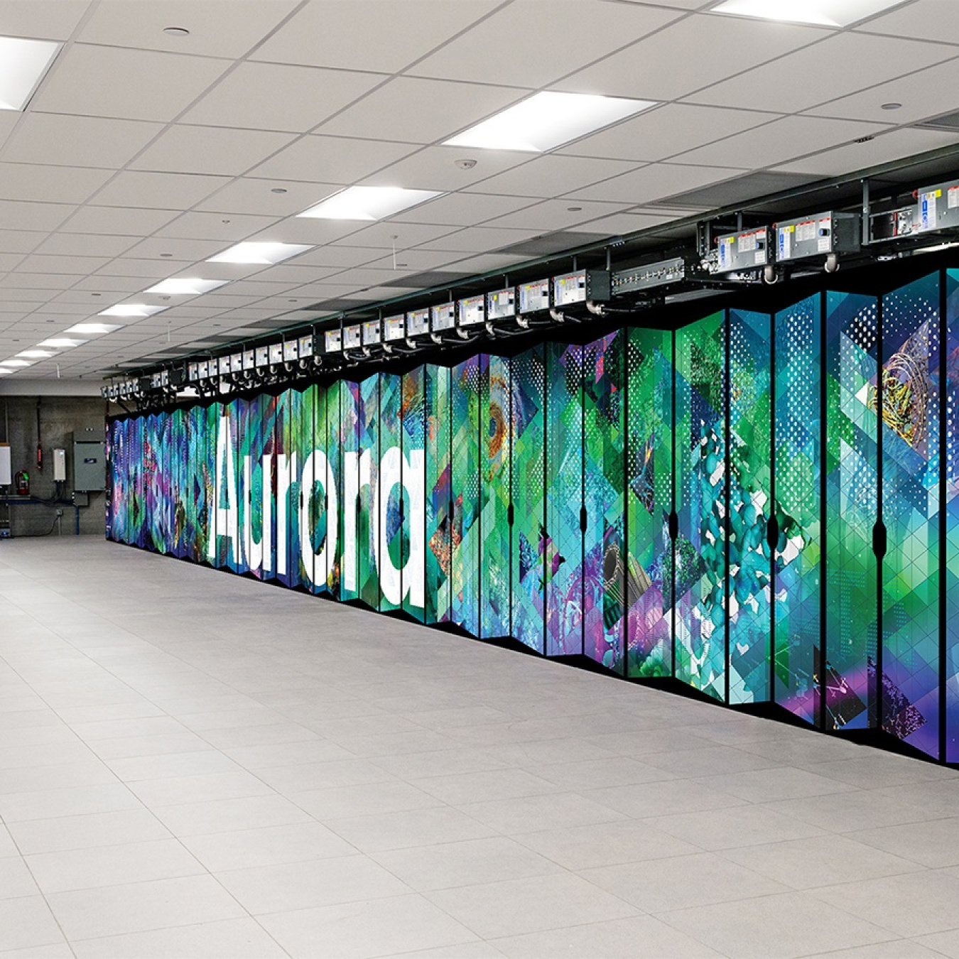 An image of the Aurora supercomputer cabinet, which has its name on it and a variety of abstract scientific symbols and patterns