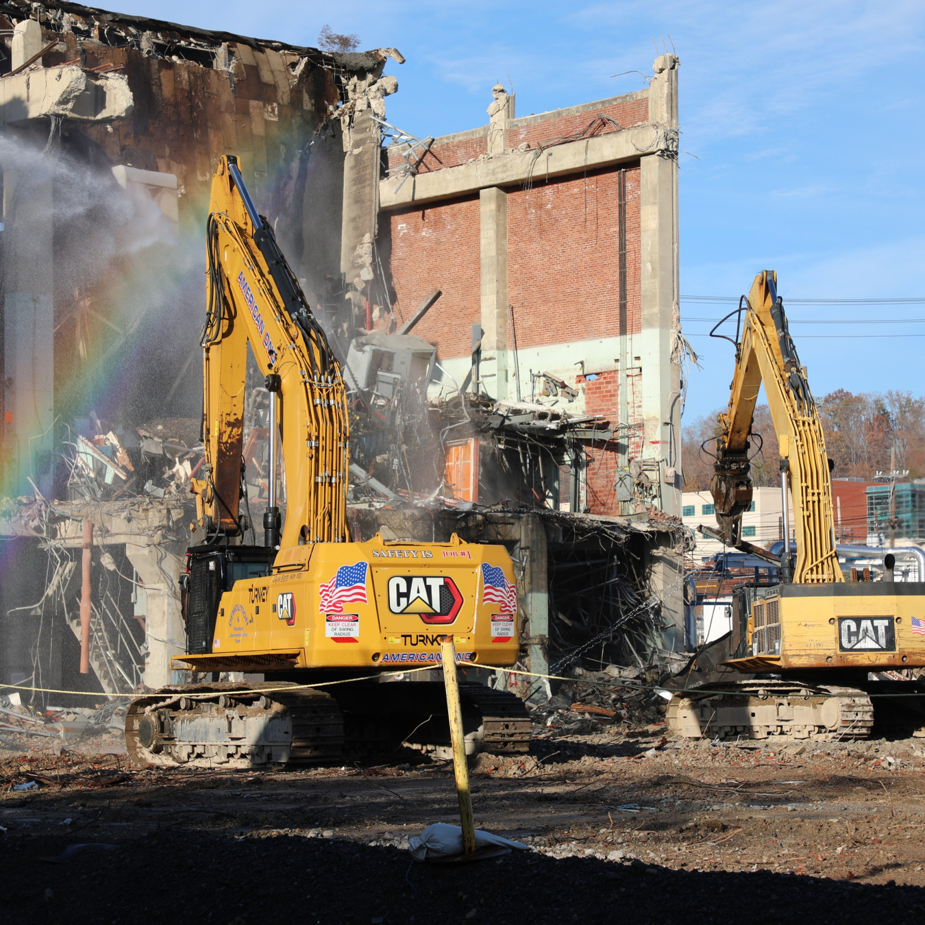 Two construction vehicles demolishing a building at the Oak Ridge site