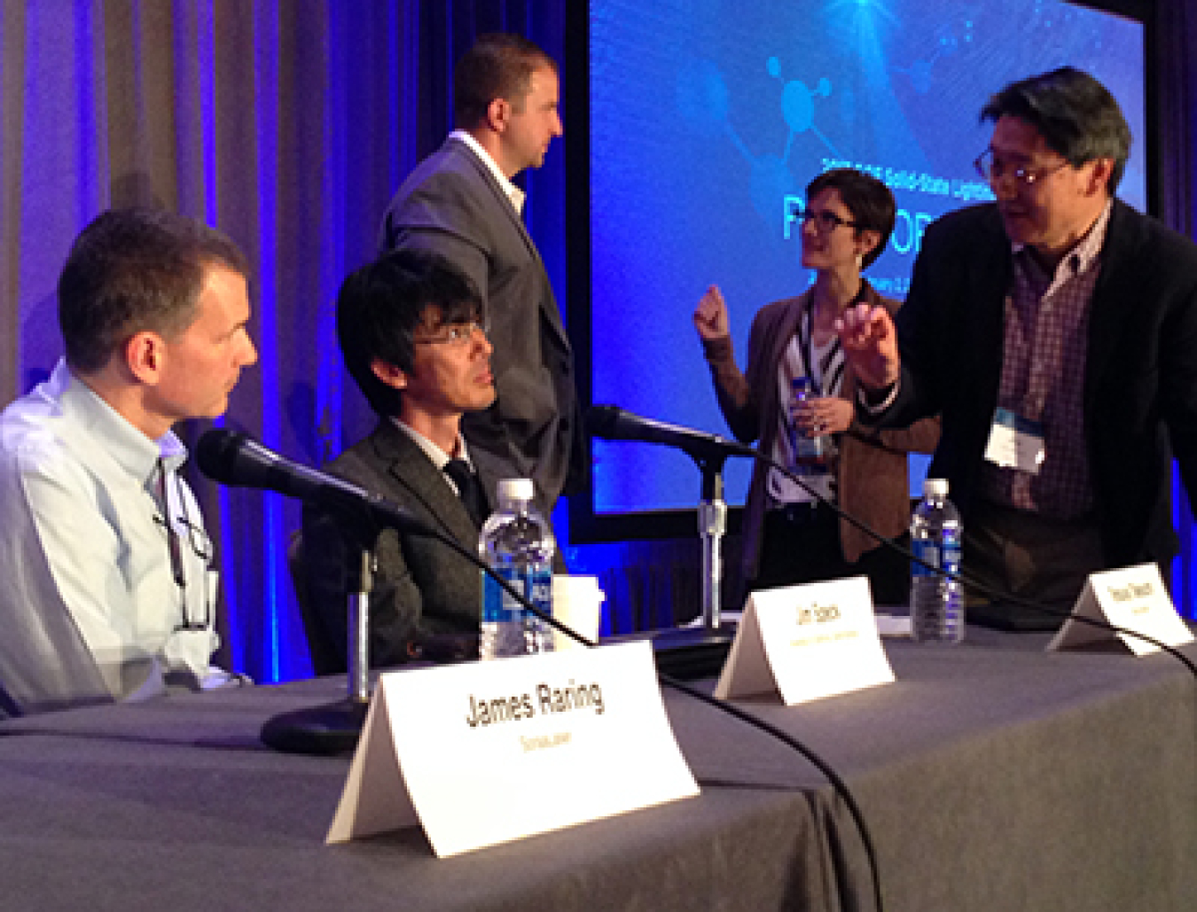 Members of a panel on light-emitting materials, physics, and devices interact with audience members during a break.