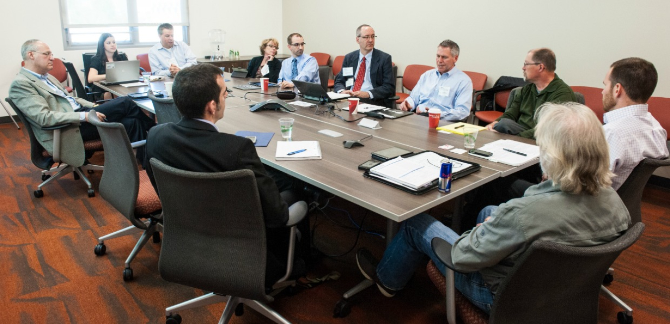 Group of people sitting around a table in a meeting room.